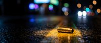Lost smartphone lying on wet asphalt street at night with colorful bokeh lights from city traffic creating atmospheric urban scene for technology concepts.
