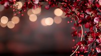 Red cherry blossom branches with delicate pink flowers against dark blurred background with soft bokeh lights creating romantic spring atmosphere.