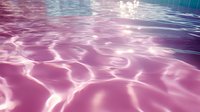 Mesmerizing pink and purple water surface with rippling light reflections creating abstract patterns, suitable for relaxing spa and wellness backgrounds.