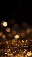 Golden glitter bokeh lights on dark background with defocused sparkles and shimmering particles creating magical festive atmosphere.