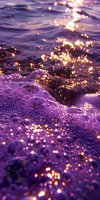 Sunlight sparkles on purple ocean waves creating magical bokeh effect and foam patterns, suitable for dreamy nature backgrounds and romantic designs.