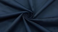 Twisted navy blue fabric creating spiral pattern with soft folds and wrinkles, showing textile texture and movement in dark moody lighting.