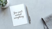Motivational quote card with pen on desk workspace featuring inspirational message about letting go of control for mindfulness and personal growth.