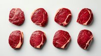 Raw beef steaks arranged in two rows on white background, isolated fresh red meat cuts with marbling, top view flat lay for food and culinary use.