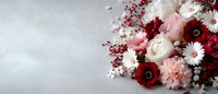 Elegant floral arrangement with red and pink flowers including roses, chrysanthemums and white blooms on light background for romantic occasions.