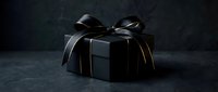 Elegant black gift box with luxurious satin ribbon bow on dark textured surface for premium packaging, special occasions, holidays and celebrations.