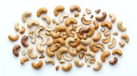 Scattered cashew nuts in various sizes on white background, isolated and ready for food, nutrition, and culinary design projects.