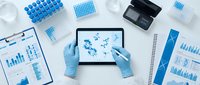 Scientist in blue gloves analyzing molecular structures on tablet with laboratory equipment and data charts for medical research and biotechnology studies.