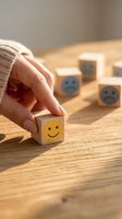 Hand choosing a wooden cube with a happy smiley face among sad ones on a table, symbolizing positivity, mental health, and customer satisfaction.