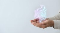 Hands holding holographic stomach organ with digestive system visualization for medical education and healthcare technology presentations.