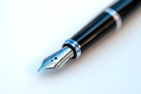 Close-up macro shot of fountain pen nib with metallic blue accents on white background, selective focus creates soft dreamy blur effect for writing and creativity.