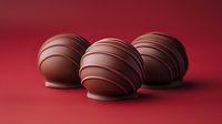 Chocolate truffles with elegant drizzle patterns on red background for Valentine's Day, romantic gifts, confectionery marketing and dessert photography.