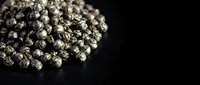 Cluster of metallic silver spheres arranged together on dark surface, creating textured abstract composition for design and creative projects.