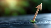 Growing arrow symbol emerging from crack in concrete with green sprout, representing breakthrough, growth and success against natural bokeh background.