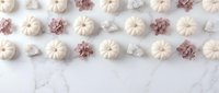 Autumn flat lay with white pumpkins and pine cones arranged in rows on marble background for seasonal decoration and fall crafting projects.