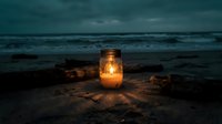 Glowing lantern on sandy beach at twilight with ocean waves and driftwood creating romantic coastal atmosphere for meditation and relaxation concepts.