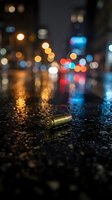 Spent bullet casing on wet urban street at night with blurred city lights and traffic signals reflecting on pavement, suitable for crime, danger, or noir-themed designs.