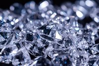 Macro shot of crushed ice crystals with blue reflections and bokeh effect creating abstract luxury background pattern. Frozen water close-up with selective focus.