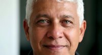 Professional mature Caucasian businessman with gray hair and confident smile in corporate office environment for business leadership concepts.