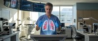 Middle-aged Caucasian male doctor examining holographic lung display in modern medical laboratory with advanced diagnostic equipment and microscopes.