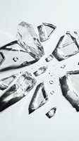 Shattered glass fragments and ice cubes scattered on white surface with dramatic shadows, suitable for beverage, luxury, and abstract design projects.