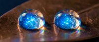 Two luminous blue crystal spheres with glowing inner light effects resting on rustic wooden surface creating magical ambient atmosphere for fantasy designs.