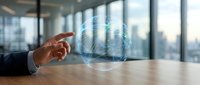 Businessman hand touching digital globe hologram on wooden desk with city skyline background, representing global business, technology, and international commerce.