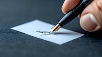 Close-up view of fountain pen writing signature on white paper against dark background, demonstrating elegant penmanship and professional document signing process.