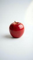Fresh red apple with glossy skin and stem isolated on white background, suitable for food, nutrition, health and wellness design projects.