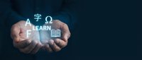 Hands holding glowing education symbols and learn text on dark blue background, representing online learning, knowledge acquisition, and digital training for students and professionals.
