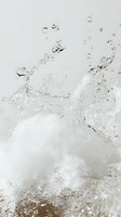 Clear water splash with rising bubbles and dynamic motion captured against light background, creating abstract patterns of liquid movement and droplets in macro photography.
