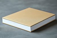 Hardcover book with golden cover and white pages lying on gray surface, minimalist design for mockup and publishing presentation purposes.