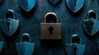 Metal padlocks in blue and bronze tones arranged on dark textured background, creating dramatic pattern of security symbols with central focus on locked bronze padlock.