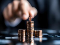 Male hand stacking copper coins in ascending columns on dark background, demonstrating financial growth, investment strategy and wealth management concept.