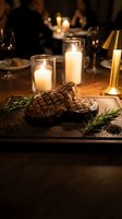 Grilled beef steaks with rosemary herbs on wooden board in elegant candlelit restaurant setting for fine dining and culinary presentations.