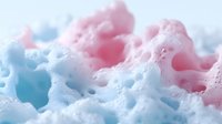 Colorful soap foam bubbles in pink and blue hues creating abstract texture for cleaning products, bath time concepts, and hygiene marketing materials.