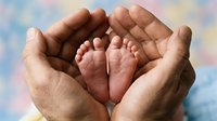 Adult hands cradling newborn baby feet against soft pastel background. Tender moment capturing parental care, love, and protection for healthcare, family, and maternity concepts.