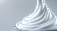 Smooth swirls of pure white cream or soft serve ice cream creating elegant curves and waves against light gray background, macro photography for food industry.