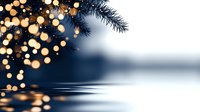 Festive spruce branch with golden bokeh lights reflecting on calm water surface against blurred winter background, creating magical holiday atmosphere.