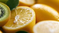 Sliced kiwi and lemon fruits with fresh citrus segments and green leaf, suitable for food photography, healthy eating content, and culinary design projects.