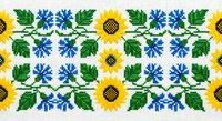 Traditional Ukrainian embroidery pattern with sunflowers and blue flowers on white background. Folk art cross-stitch design for textile decoration.