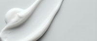 White cream or lotion texture smear on clean background showing smooth cosmetic product application for skincare and beauty treatments.