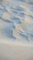 Footprints in wet sand at beach shore with shallow depth of field creating artistic blur effect for travel and vacation concepts.