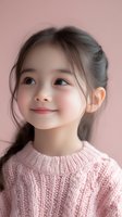 Adorable Asian girl with braided hair wearing pink knit sweater smiling warmly against soft pink background for children fashion and lifestyle concepts.