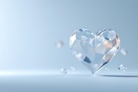 Crystal heart shape with faceted surface floating on light blue background, romantic minimalist composition for wedding and valentine designs.