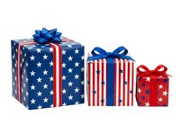 Patriotic gift boxes with stars and stripes pattern in red, white, and blue, featuring coordinating bows, isolated on white background for holiday and celebration designs.