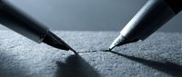 Two fountain pens with black and silver barrels positioned on textured gray paper, tips touching to form a point, symbolizing agreement, partnership, and contract signing for business and legal concepts.