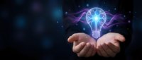 Cupped hands presenting glowing lightbulb with electric energy waves against dark cosmic background symbolizing innovation and creative thinking.