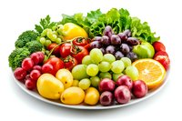 Fresh fruits and vegetables assortment on white plate. Colorful healthy food variety with grapes, tomatoes, broccoli, lettuce, strawberries, citrus, and apples.