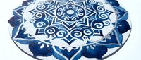 Indigo and white mandala floor mat with geometric star pattern and floral motifs, isolated on white background, ready for home decor and wellness design projects.